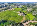 Expansive aerial view showcasing the property's land, barns, outbuildings, and serene rural setting at 11475 Us Highway 85, Littleton, CO 80125