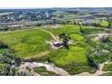 Expansive aerial view showcasing the property's land, barns, outbuildings, and serene rural setting at 11475 Us Highway 85, Littleton, CO 80125