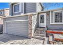 Close up of home featuring the front entry, address, two car garage and landscaped entrance at 9851 Castle Ridge Cir, Highlands Ranch, CO 80129