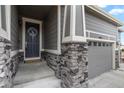 The main entrance of the house with a welcoming door and beautiful stone accents at 5723 Berry Ridge Way, Castle Rock, CO 80104