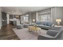 Cozy living room with a large window providing natural light, open to modern kitchen and dining area at 5723 Berry Ridge Way, Castle Rock, CO 80104