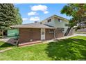 Back exterior of brick home featuring a carport, small yard, and stairs to the second story at 3631 W 79Th Ave # A2, Westminster, CO 80030