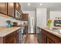 Modern kitchen with stainless steel appliances, dark wood cabinets, and stone countertops at 1518 Sepia Ave, Longmont, CO 80501