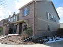 Rear view of a charming townhouse with a brick facade, private patio, and a convenient outdoor grilling area at 559 Alton Way # E, Denver, CO 80230