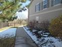Well maintained side yard with a sidewalk leading toward a black metal fence and flowering bushes at 559 Alton Way # E, Denver, CO 80230