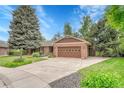 Charming brick home featuring a well-manicured lawn, beautiful landscaping, and a two-car garage at 5964 S Florence Ct, Englewood, CO 80111