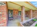 Inviting covered front porch with brick columns, a front door, and space for decorative plants and seating at 2311 Emery Pl, Longmont, CO 80501