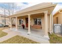 Inviting front porch with swing, complemented by elegant columns and charming details at 3929 Shoshone St, Denver, CO 80211