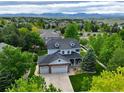 Aerial view of beautiful two-story home with lush greenery and mountain backdrop at 14675 Golden Eagle Run, Broomfield, CO 80023