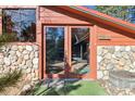 Warm and welcoming entrance with wood-framed glass doors and stone accents, adding to the cabin's allure at 21345 Cliffwoods Trl, Morrison, CO 80465