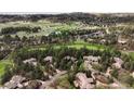 Aerial view showcases the property's location on golf course and its surrounding wooded landscape at 1070 Cypress Way, Castle Rock, CO 80108