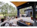 Relaxing outdoor patio featuring a built-in grill, fire pit, and comfortable seating with views of the surrounding landscape at 1070 Cypress Way, Castle Rock, CO 80108