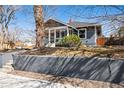 Charming blue two-story home featuring a well-maintained yard and concrete retaining wall in the front at 5094 Meade St, Denver, CO 80221