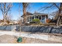 Charming blue two-story home with front yard landscaping and sidewalk access on a sunny day at 5094 Meade St, Denver, CO 80221