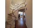 Grand foyer with hardwood floors, curved staircase and a view of the living room at 14241 Ivanhoe St, Thornton, CO 80602