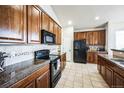 Well-equipped kitchen with granite countertops, tile backsplash, and modern appliances at 1563 Bellflower Dr, Brighton, CO 80601