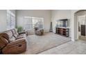 Bright living room featuring plush carpeting, comfortable seating, and a large window at 1563 Bellflower Dr, Brighton, CO 80601