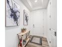 Inviting entryway featuring modern decor, wood floors, and a white front door at 2598 Knobbie Cir, Castle Rock, CO 80109