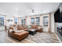 Bright living room area featuring lots of windows, a leather sectional, and adjacent dining room at 2598 Knobbie Cir, Castle Rock, CO 80109