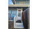 Close-up of the condo's front door with stairs and a weathered white railing at 264 S Newark Cir, Aurora, CO 80012