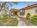 Charming brick home featuring a covered front porch and landscaped walkway at 3906 Hoyt Ct, Wheat Ridge, CO 80033