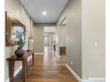 Neutral hallway with hardwood flooring, white trim, and decorative accents on wood table at 10660 Winding Pine Pt, Highlands Ranch, CO 80126