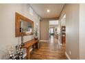 Inviting hallway features hardwood floors, neutral walls, and stylish decor at 10660 Winding Pine Pt, Highlands Ranch, CO 80126