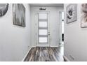 Bright entryway featuring stylish flooring, tasteful wall decor and a door with built-in blinds at 802 Eva Peak Dr, Erie, CO 80516