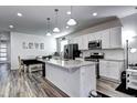 Open kitchen with white cabinets, modern stainless-steel appliances, granite countertops, and an island at 802 Eva Peak Dr, Erie, CO 80516