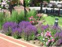 Brick trimmed flowerbeds around the complex contain colorful flowers and lush greenery at 2700 E Cherry Creek S Dr # 302, Denver, CO 80209