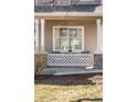 Inviting front porch with decorative lattice, stone accents, and outdoor seating at 5174 W 123Rd Pl, Broomfield, CO 80020