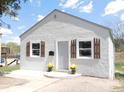 Charming single story home featuring a stucco exterior, decorative shutters, and yellow flowers adorning the front porch at 9180 Spruce Mountain Rd, Larkspur, CO 80118