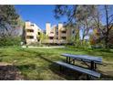 Exterior view of landscaped community space with green grass, dandelions, and a picnic table at 2711 Mapleton Ave # 1, Boulder, CO 80304