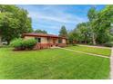 Attractive one story home with a lush green lawn and mature trees at 8675 Calvin Dr, Arvada, CO 80002