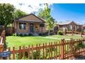 Inviting front yard with lush green grass and a charming wooden fence, highlighting curb appeal at 2415 Pontiac St, Denver, CO 80207