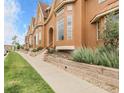 Attractive townhomes with manicured landscaping, and a well-maintained sidewalk at 18061 E Saskatoon Pl, Parker, CO 80134