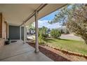 Inviting covered front porch with classic columns offering views of the landscaped front yard and neighborhood at 9926 W Nova Pl, Littleton, CO 80127