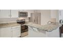 Modern kitchen featuring stainless steel appliances, granite countertops, and a breakfast bar at 5550 W 80Th Pl # 1, Arvada, CO 80003