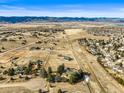 Expansive aerial view of the property surrounded by rural landscape and mountain views at 10963 N Chatfield Dr, Littleton, CO 80125