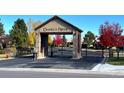 Community entrance with stone pillars, gated entry, and manicured landscaping on a sunny day at 6772 Vista Lodge Loop, Castle Pines, CO 80108