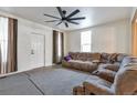 Cozy living room with plush gray sectional, large ceiling fan, and natural light from a large window at 14050 W 8Th Ave, Golden, CO 80401