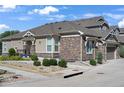 Inviting home with stone and siding, well-kept landscaping, and a walkway leading to the entrance at 14916 E Crestridge Pl, Centennial, CO 80015