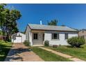 Quaint single-story home with a well-manicured lawn and detached garage at 3311 S Eudora St, Denver, CO 80222