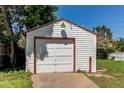 Detached garage with a white door framed in red, complemented by a green lawn at 3311 S Eudora St, Denver, CO 80222