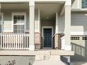 Dark-colored front door with sidelights and a white porch at 17355 E 91St Pl, Commerce City, CO 80022