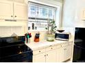 Bright kitchen features white cabinets, tiled countertops, and modern appliances at 215 E 11Th Ave # A11, Denver, CO 80203