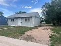 Image of the front of a light blue house with a gravel driveway on a sunny day at 804 S 1St Ave, Brighton, CO 80601
