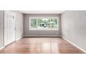 Empty room with wood floors, white trim and a large window with views of the neighborhood at 5635 Nebraska Way, Denver, CO 80224