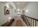 Hallway features a bench, decorative rug, stair rail, and an open view to other rooms at 10632 Star Thistle Ct, Highlands Ranch, CO 80126