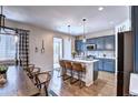 Open kitchen featuring blue cabinets, an island with seating, and modern pendant lighting at 7470 Blue Water Ln, Castle Rock, CO 80108